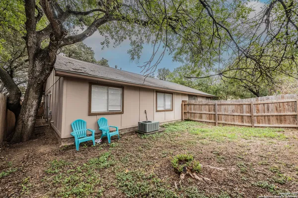 a backyard of a house with barbeque oven table and chairs