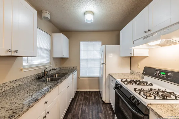 a kitchen with stainless steel appliances granite countertop a stove a sink dishwasher and a refrigerator