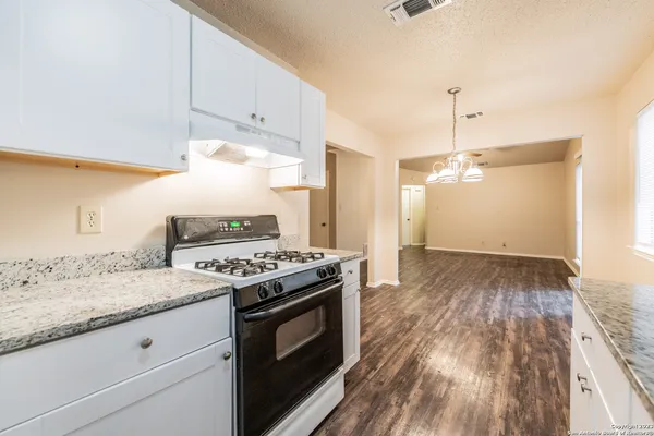 a kitchen with a stove and a wooden floor