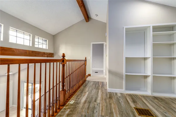a view of a hallway with wooden floor and windows