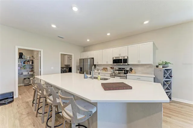 a kitchen with kitchen island white cabinets and stainless steel appliances