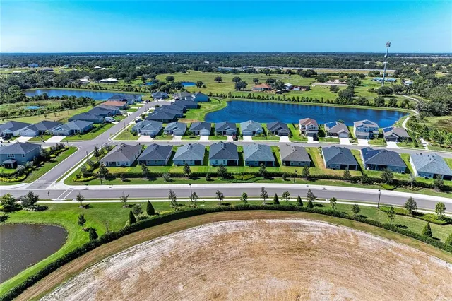 an aerial view of residential houses with outdoor space and ocean view