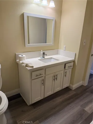 a bathroom with a granite countertop toilet sink and mirror