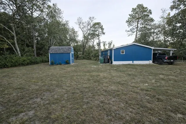a view of an house with backyard space and trees