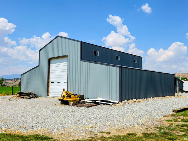 802 East 3200 Road North Preston, ID 83263 - Photo 10 of 59 Spacious metal utility building with a large roll-up door, corrugated metal siding, and a gravel lot