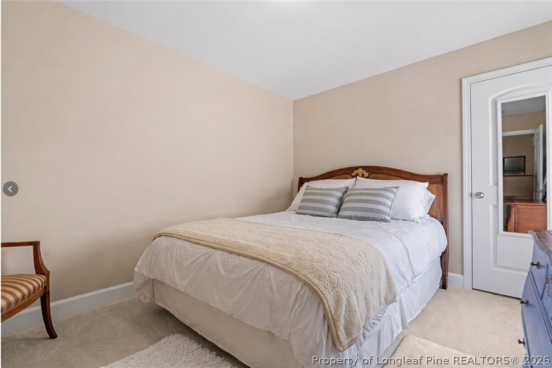 126 Pine Hawk Drive Spring Lake, NC 28390 - Photo 23 of 48 a bedroom with a bed and a lamp on the dresser