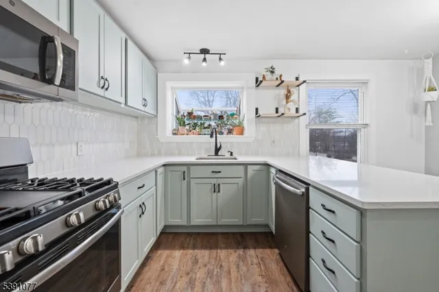 a kitchen with stainless steel appliances a sink stove and cabinets