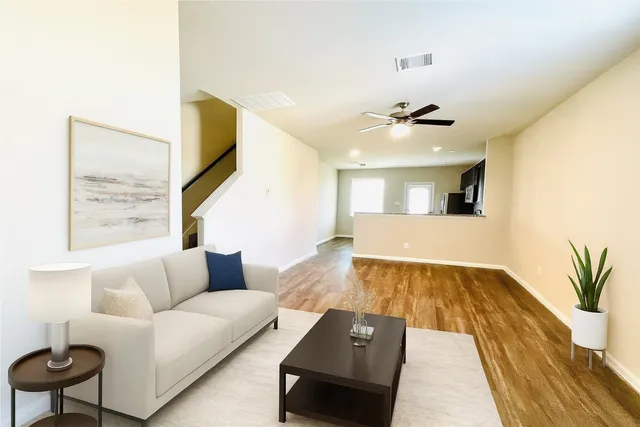 a living room with furniture and a wooden floor