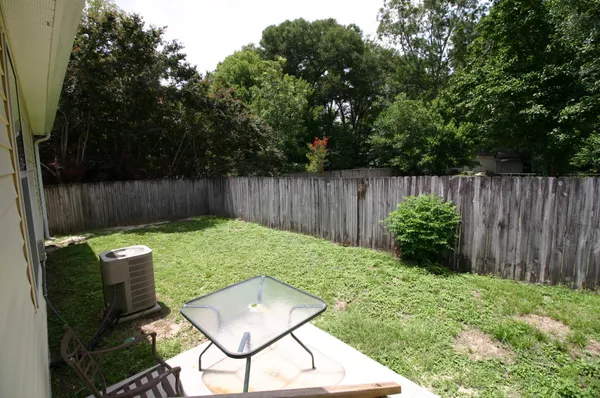 a backyard of a house with table and chairs