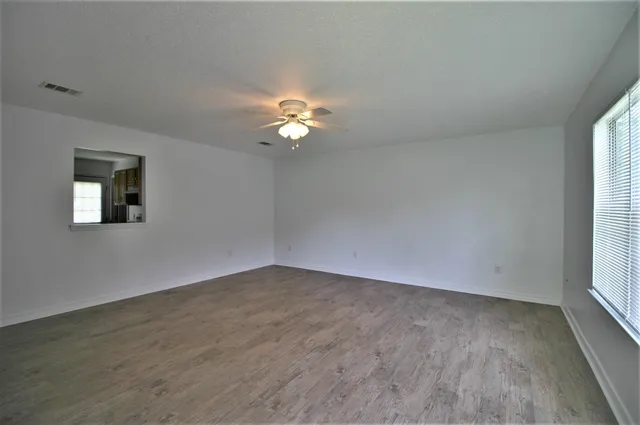 wooden floor in an empty room with a window