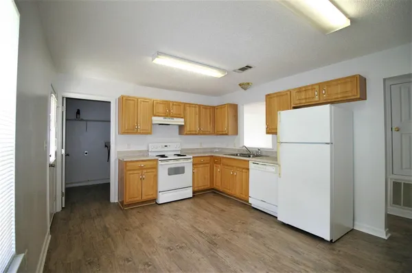 a kitchen with stainless steel appliances granite countertop a refrigerator sink and white cabinets