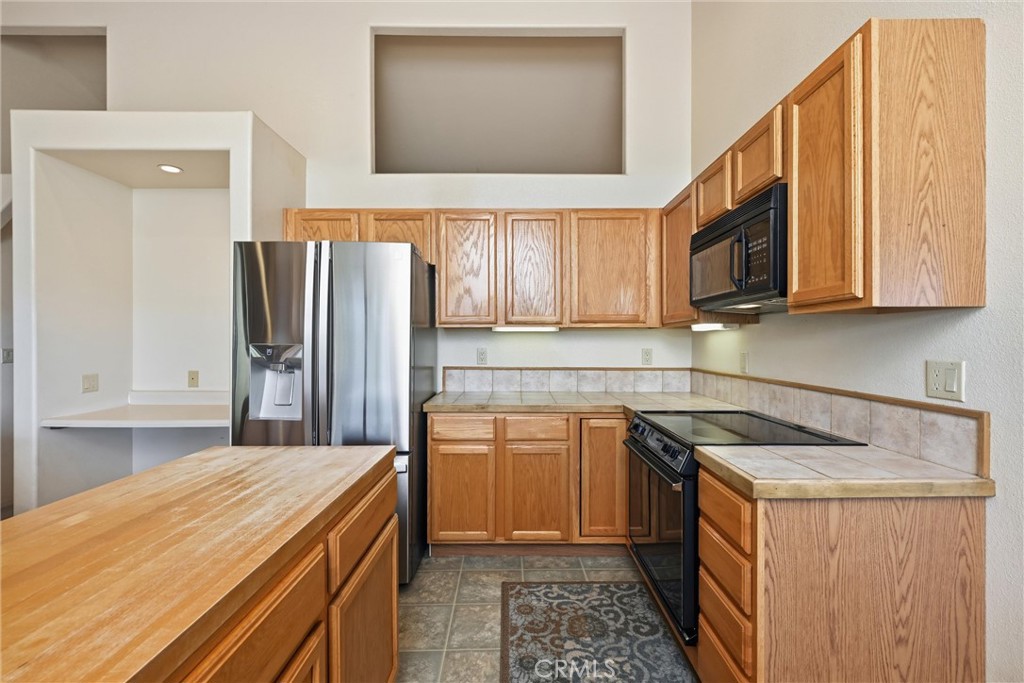 16261 Conestoga Road Hidden Valley Lake, CA 95467 - Photo 17 of 64 a kitchen with a sink a refrigerator and cabinets