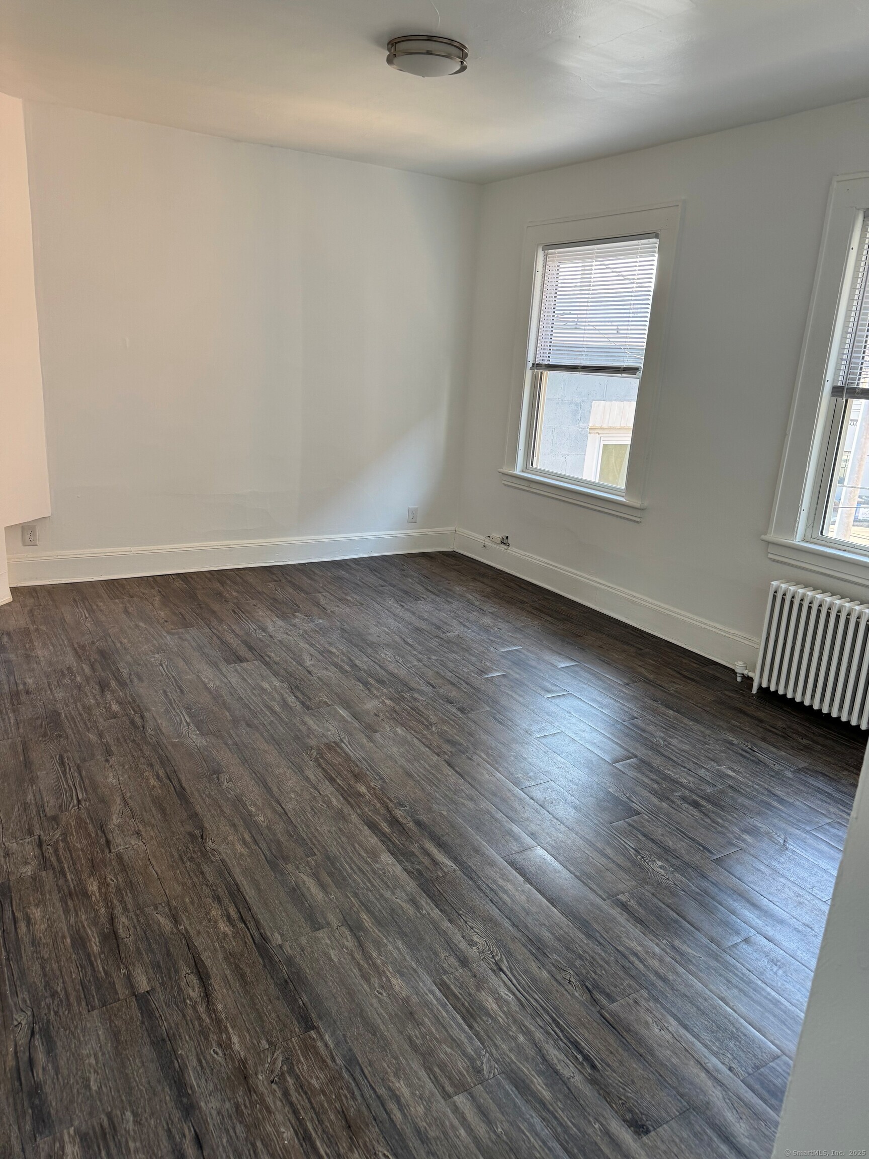 3142 Fairfield Avenue, Unit 2 Bridgeport, CT 06605 - Photo 3 of 11 an empty room with wooden floor and windows