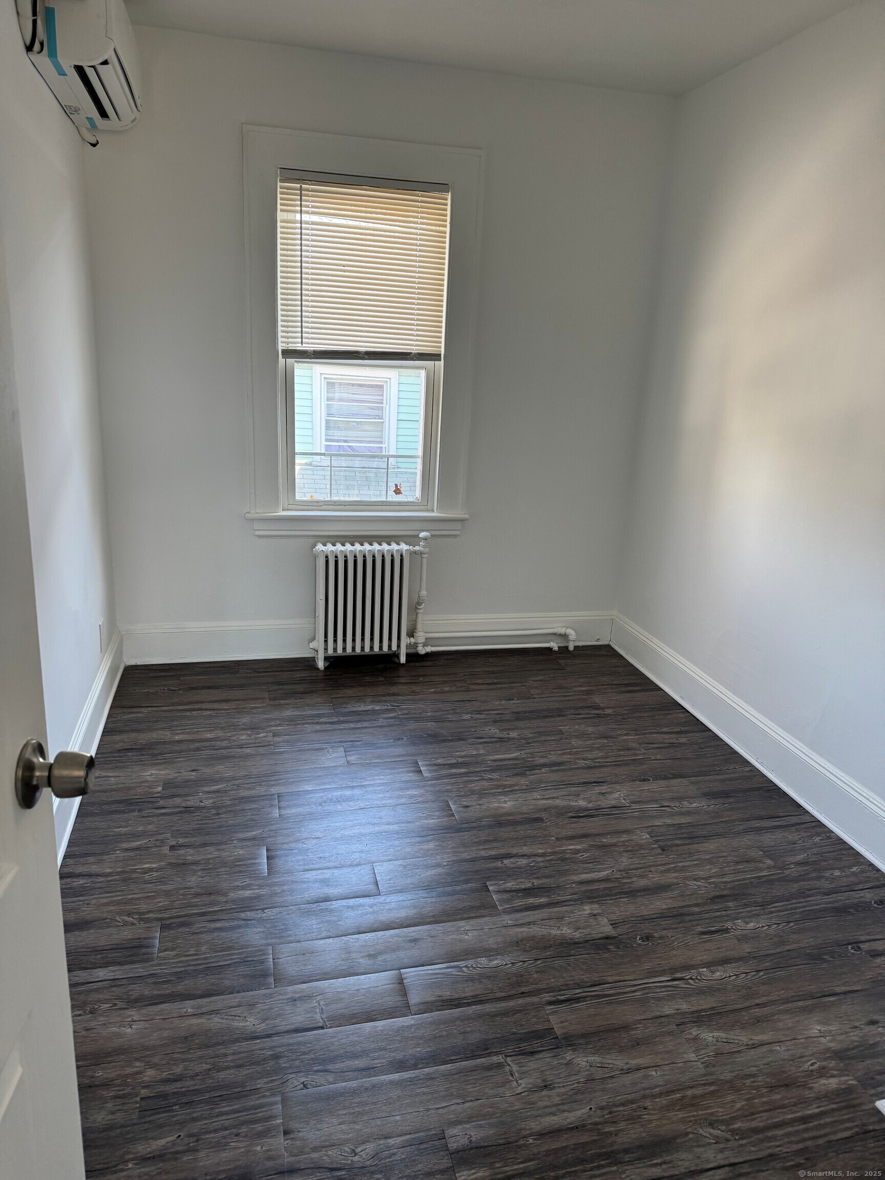 3142 Fairfield Avenue, Unit 2 Bridgeport, CT 06605 - Photo 5 of 11 an empty room with wooden floor and windows