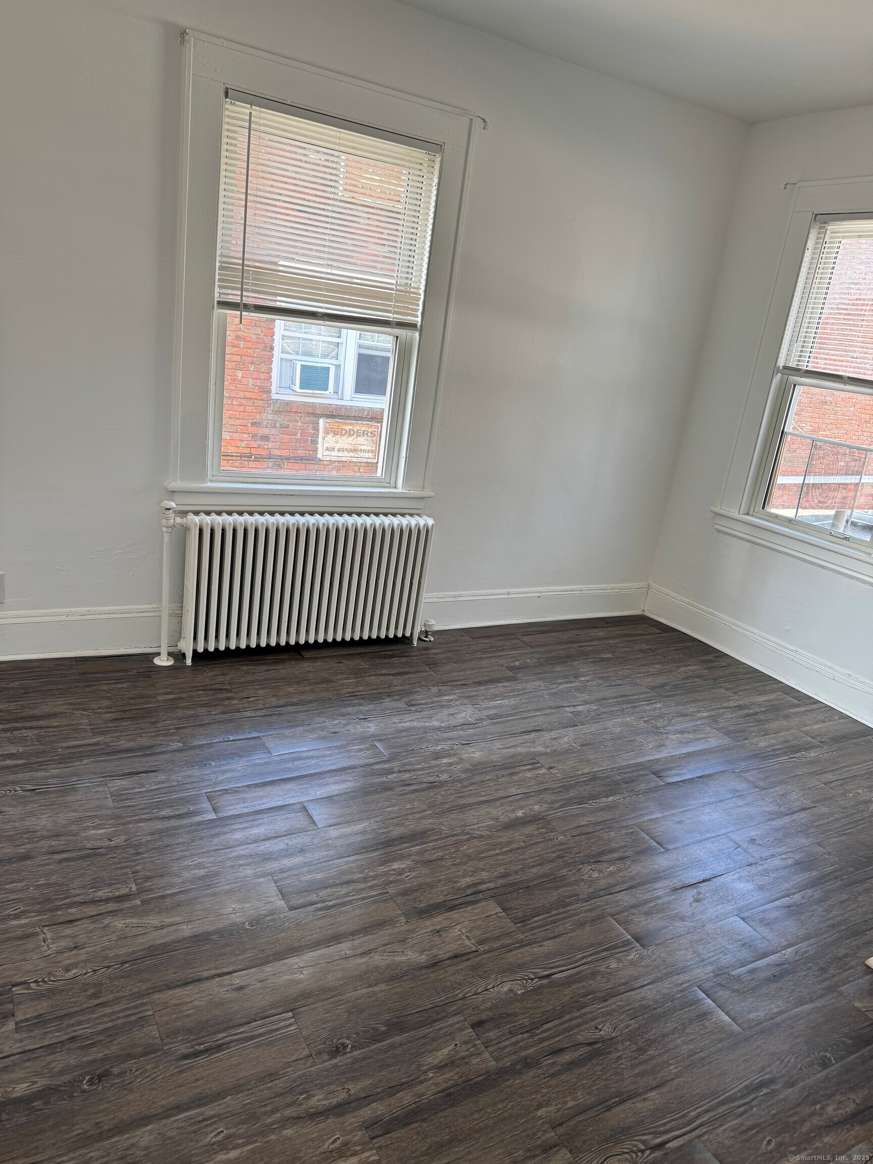 3142 Fairfield Avenue, Unit 2 Bridgeport, CT 06605 - Photo 7 of 11 an empty room with wooden floor and windows