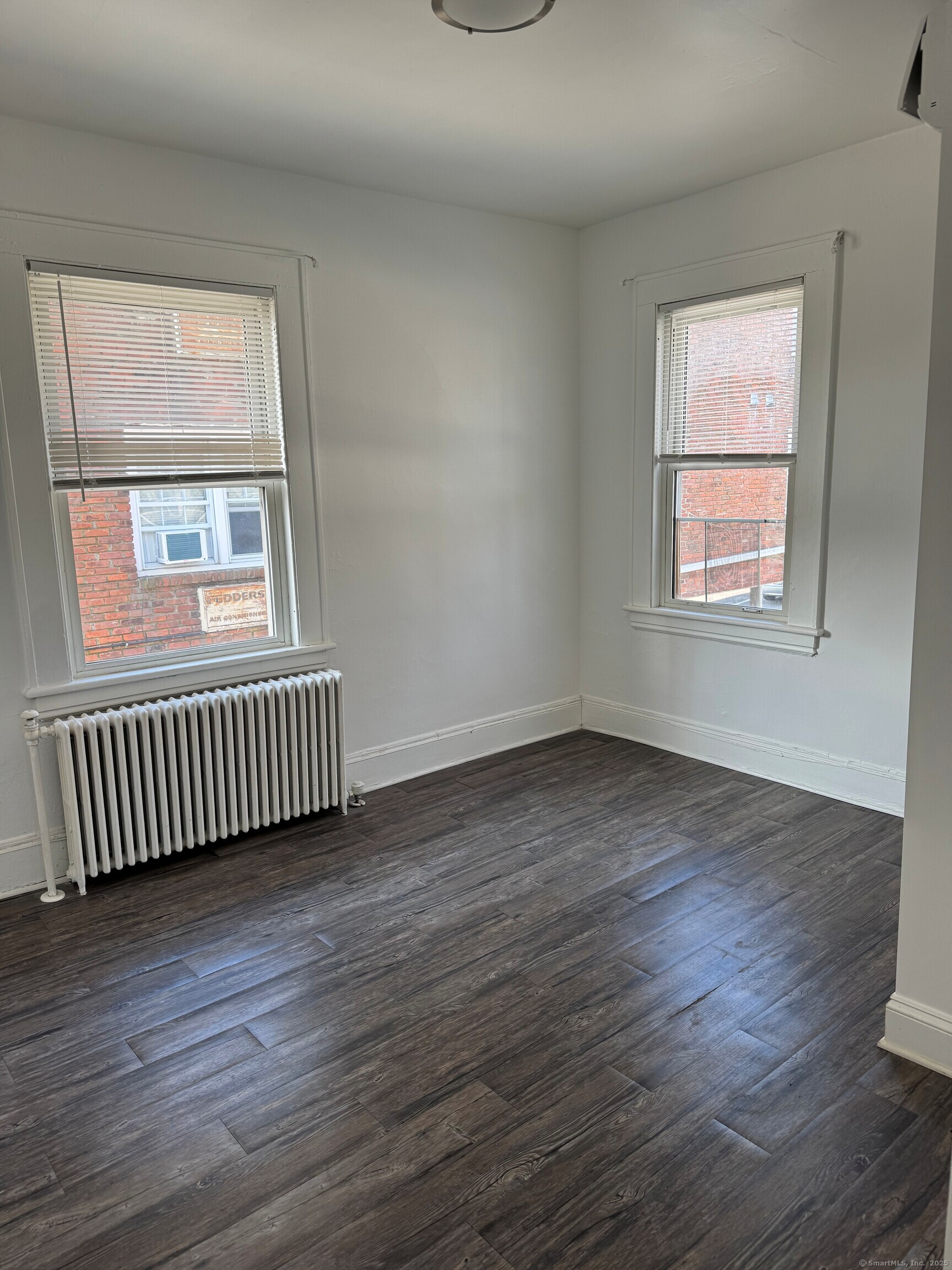 3142 Fairfield Avenue, Unit 2 Bridgeport, CT 06605 - Photo 8 of 11 a view of an empty room with wooden floor and a window