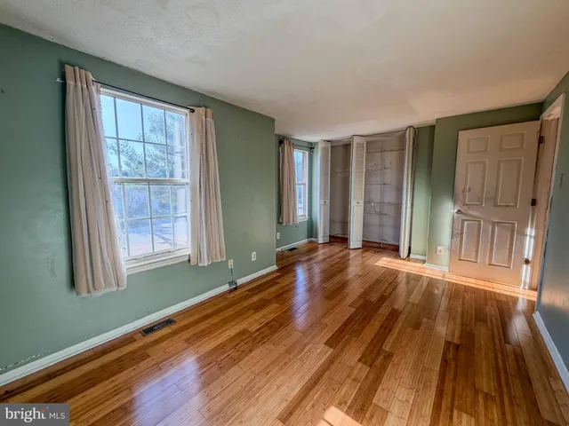 a view of a room with wooden floor and windows