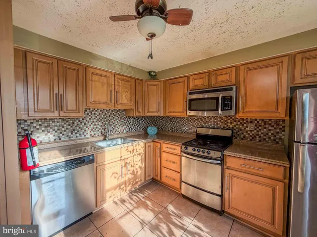 a kitchen with stainless steel appliances granite countertop a stove sink microwave and refrigerator