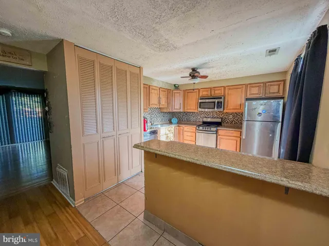 a kitchen with stainless steel appliances granite countertop a refrigerator and a stove top oven