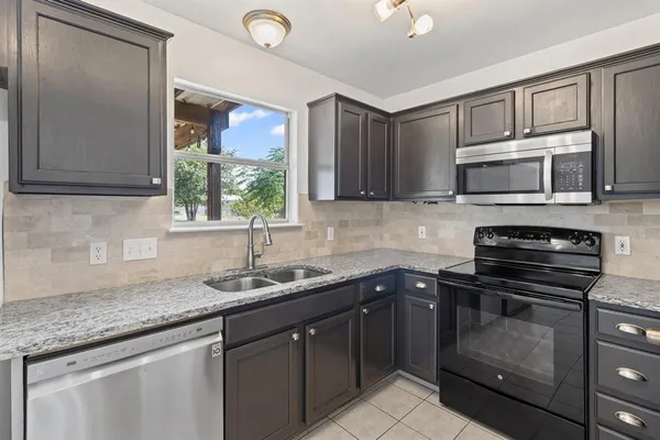 a kitchen with a sink stove and microwave