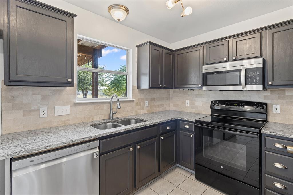 207 Panther Path Liberty Hill, TX 78642 - Photo 8 of 19 a kitchen with a sink stove and microwave