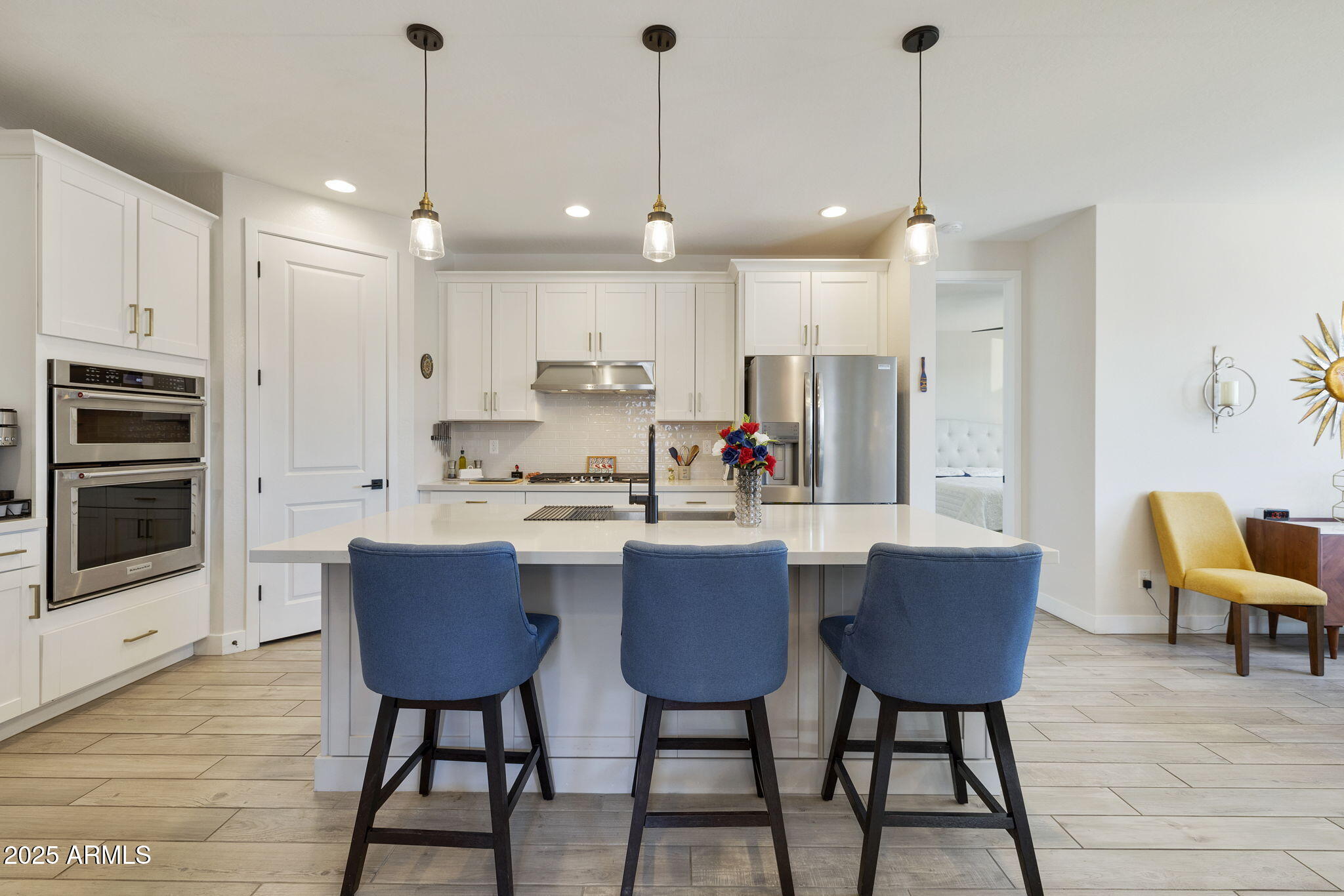 4557 South Element Mesa, AZ 85212 - Photo 4 of 34 a kitchen with stainless steel appliances granite countertop a stove a refrigerator a kitchen island a dining table and chairs with wooden floor
