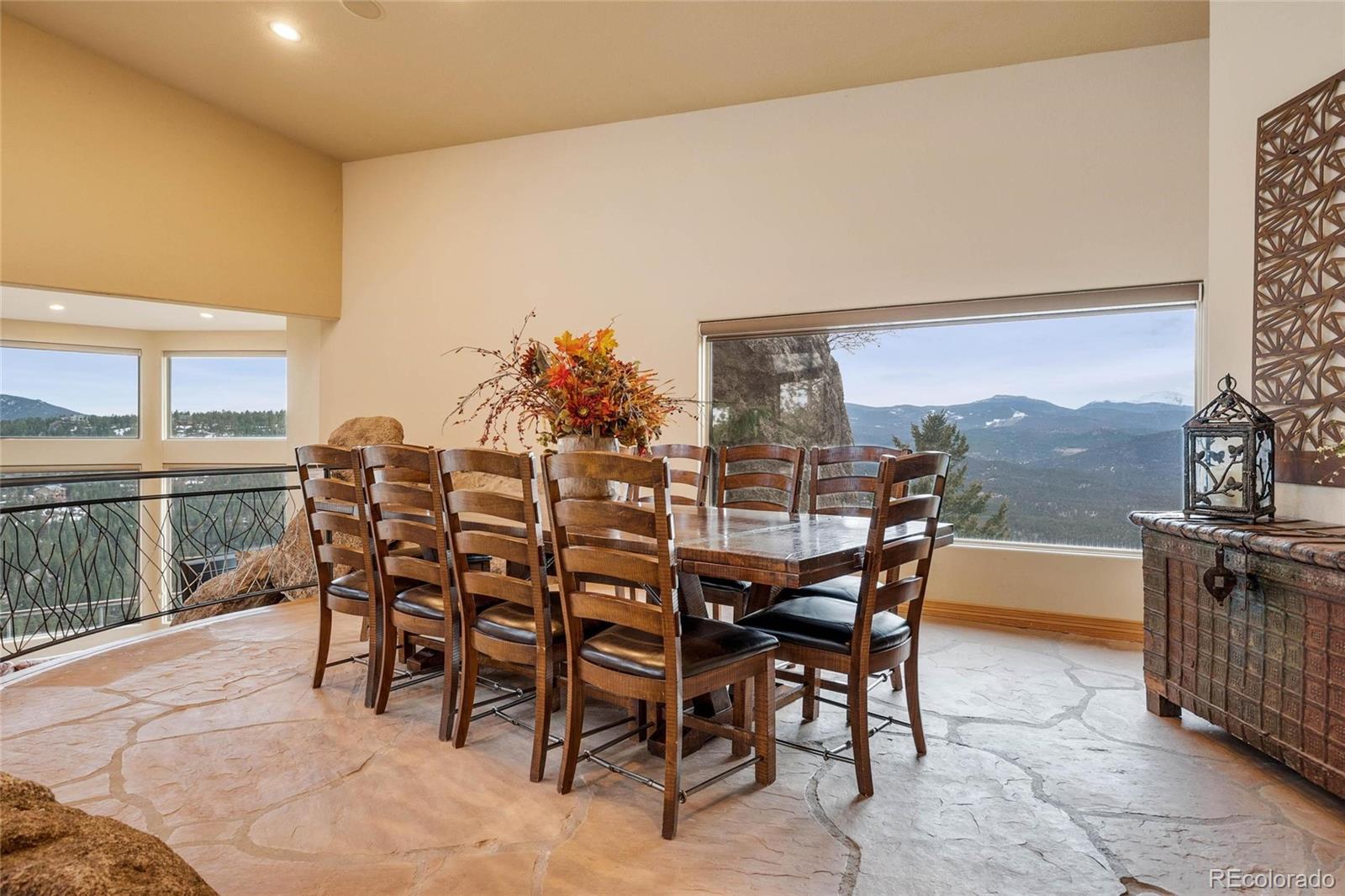 25580 Sunset Lane Evergreen, CO 80439 - Photo 11 of 40 a dining room with furniture and a floor to ceiling window