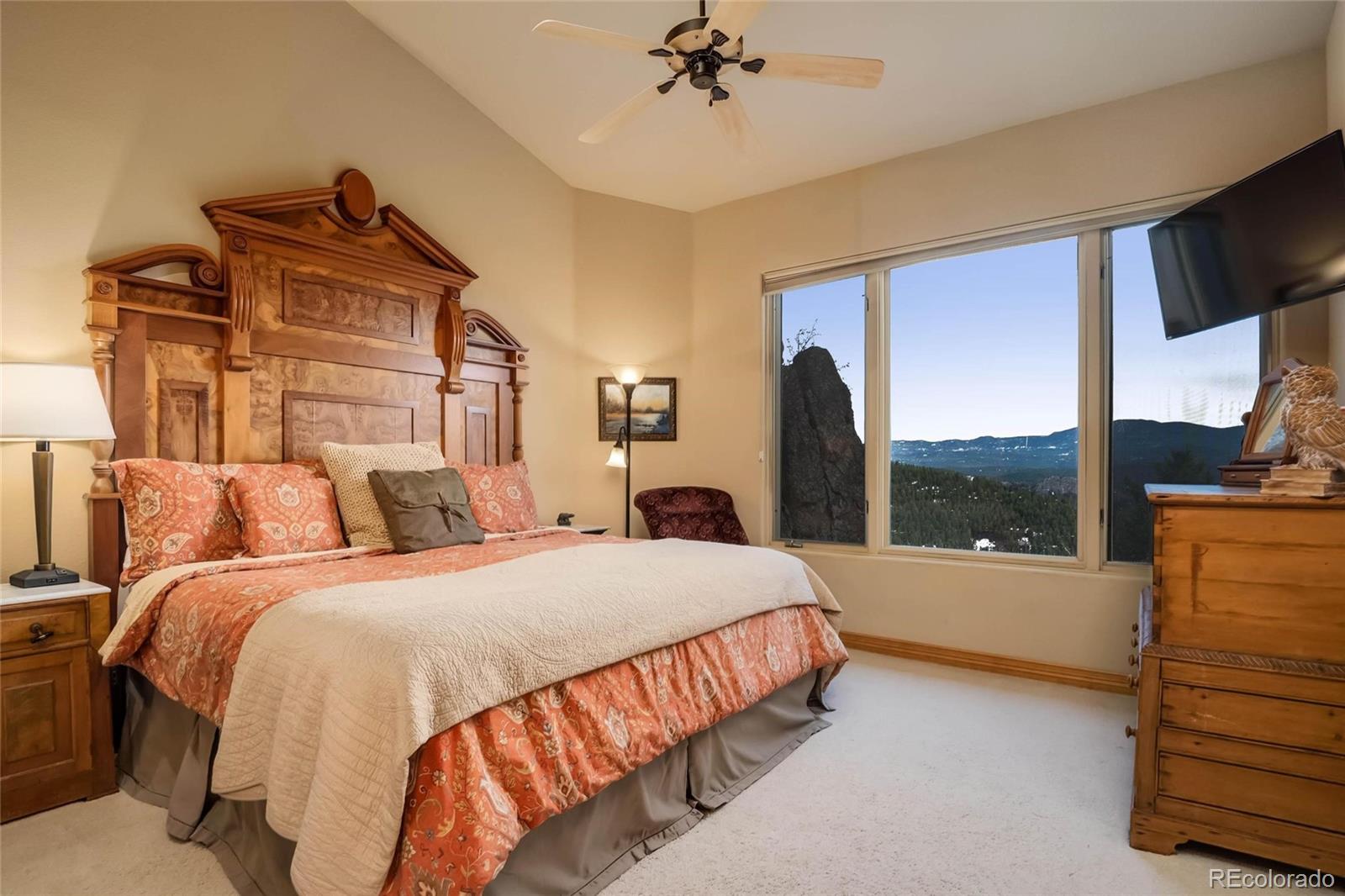 25580 Sunset Lane Evergreen, CO 80439 - Photo 24 of 40 a bedroom with a large bed and a large window