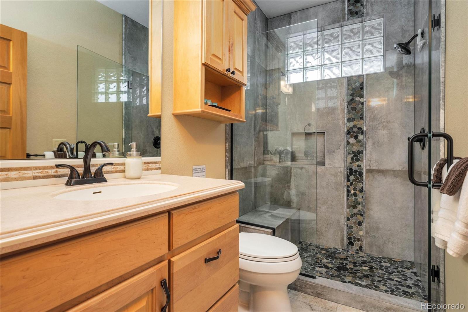 25580 Sunset Lane Evergreen, CO 80439 - Photo 27 of 40 a bathroom with a sink a toilet and shower