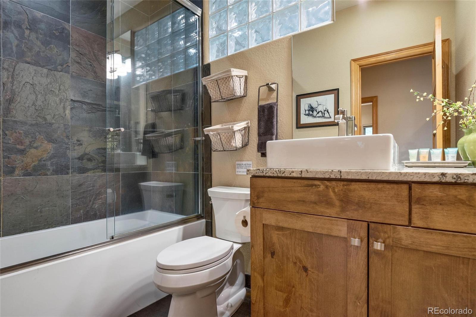 25580 Sunset Lane Evergreen, CO 80439 - Photo 29 of 40 a bathroom with a granite countertop sink toilet and shower