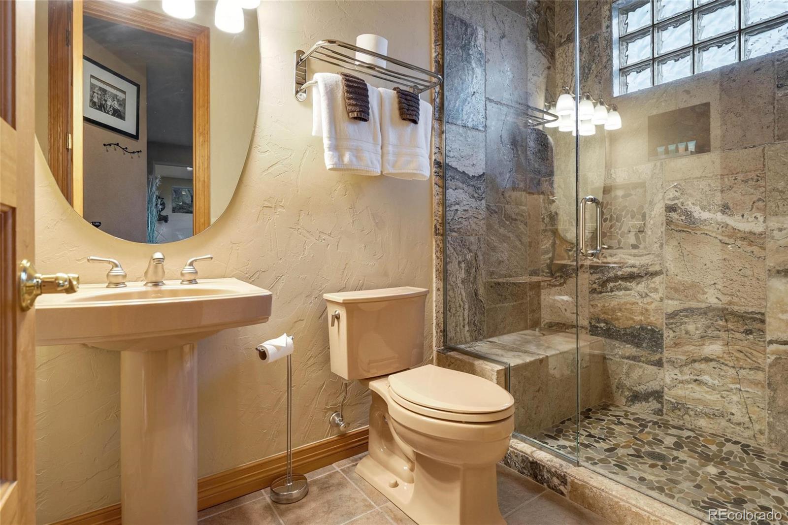 25580 Sunset Lane Evergreen, CO 80439 - Photo 35 of 40 a bathroom with a sink a toilet and shower