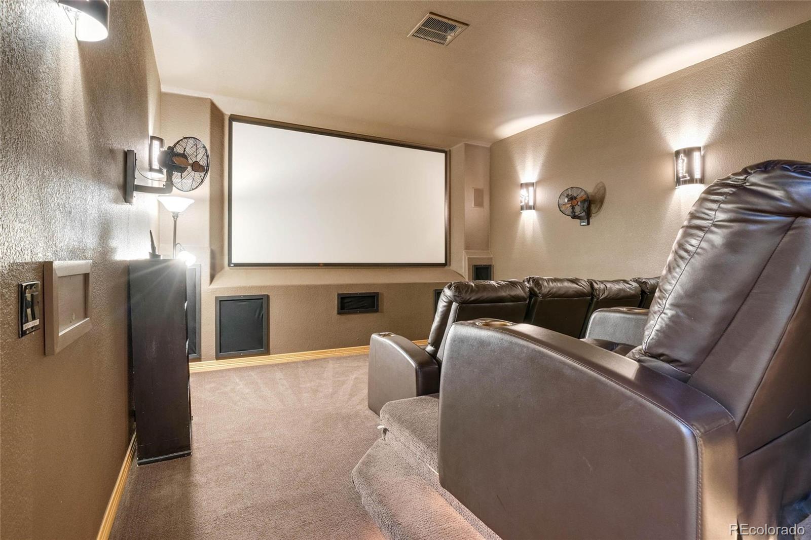 25580 Sunset Lane Evergreen, CO 80439 - Photo 37 of 40 a living room with furniture a projector and a projector screen