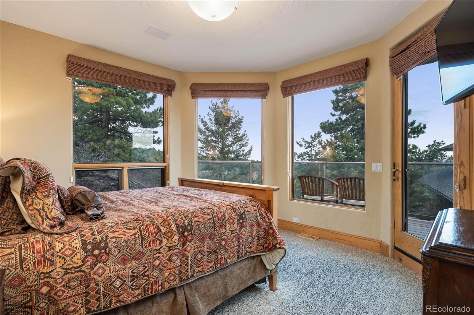 25580 Sunset Lane Evergreen, CO 80439 - Photo 38 of 40 a bedroom with a large bed and a large window