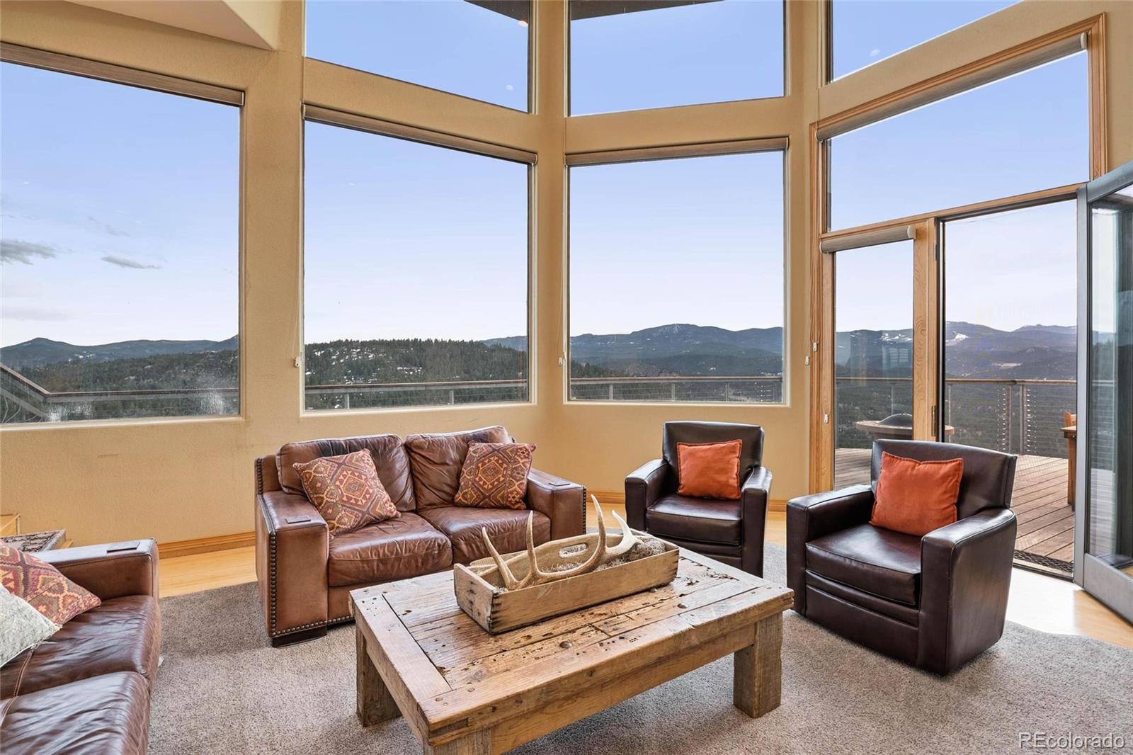 25580 Sunset Lane Evergreen, CO 80439 - Photo 9 of 40 a living room with furniture and a floor to ceiling window