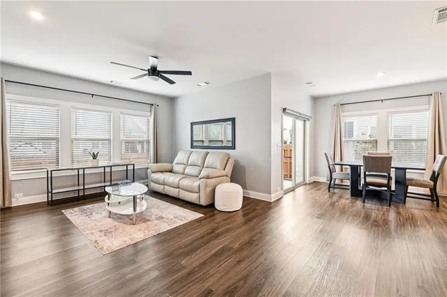 a living room with furniture a flat screen tv and kitchen view