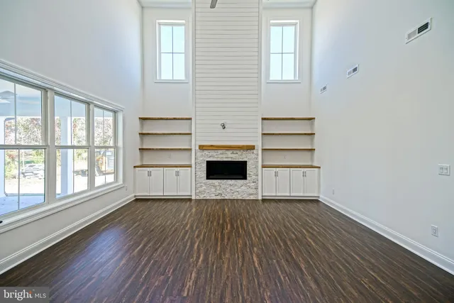a large white kitchen with granite countertop a stove top oven a sink and dishwasher with wooden floor