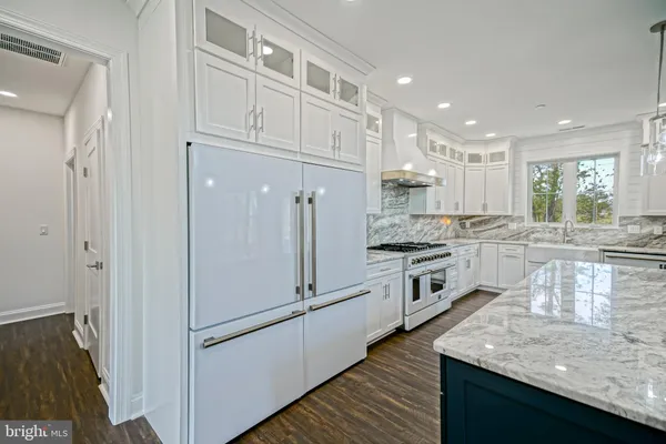 an empty room with wooden floor and a ceiling fan