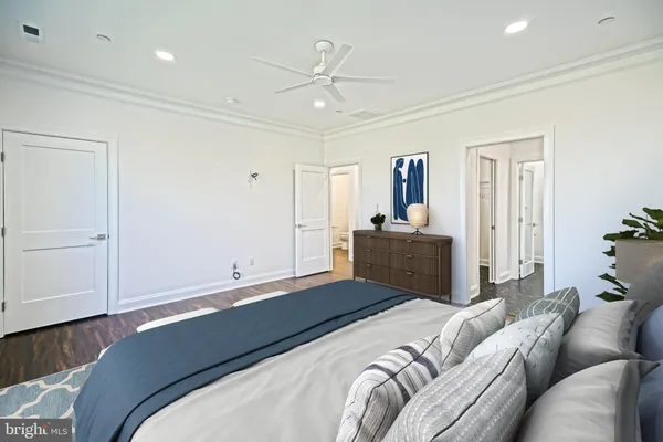 an empty room with wooden floor ceiling fan and windows