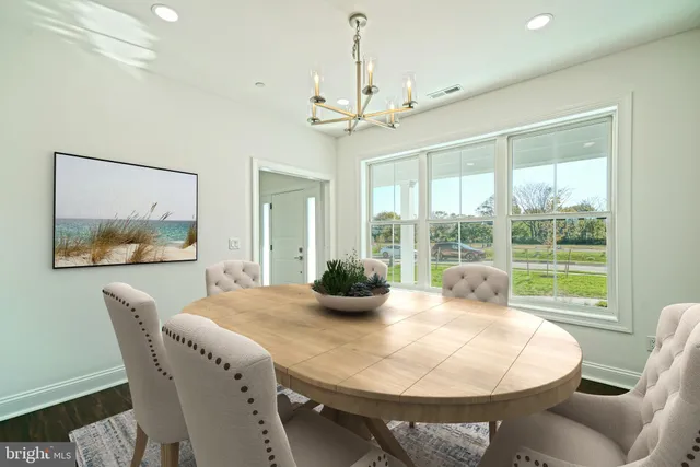a view of a room with wooden floor chandelier and windows