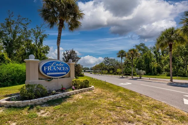 a view of a street with a yard and trees