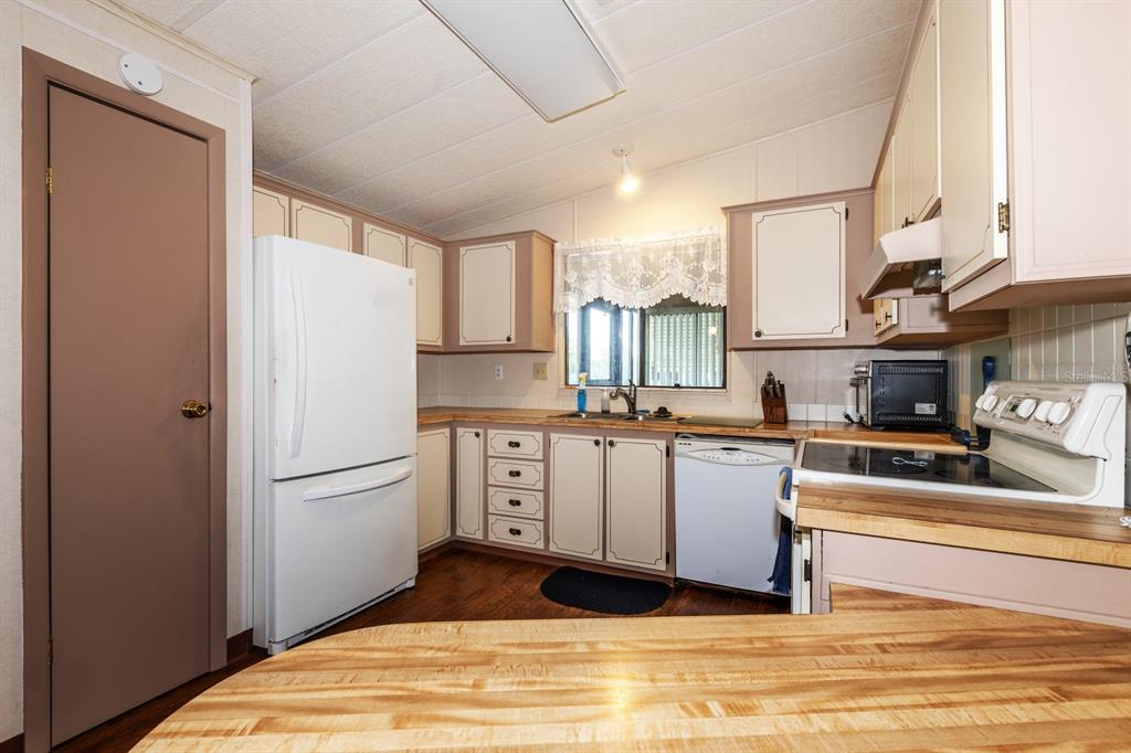 1543 Apache Circle Tavares, FL 32778 - Photo 5 of 19 a kitchen with stainless steel appliances granite countertop a refrigerator sink and cabinets