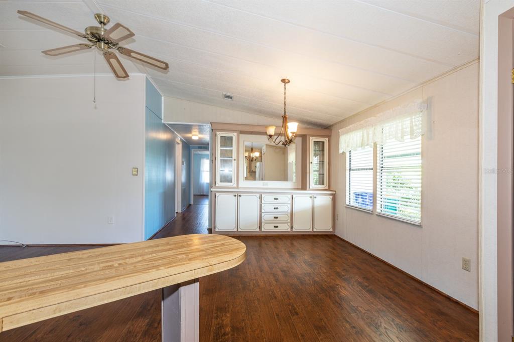 1543 Apache Circle Tavares, FL 32778 - Photo 6 of 19 a view of a room with wooden floor ceiling fan and windows