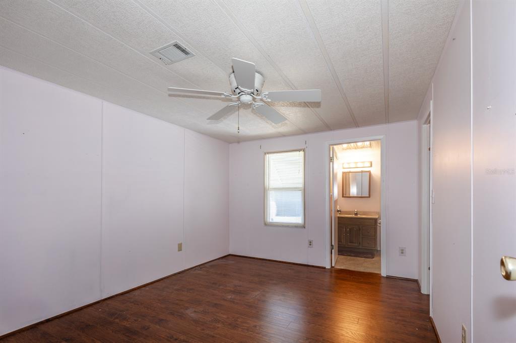 1543 Apache Circle Tavares, FL 32778 - Photo 7 of 19 an empty room with wooden floor fan and windows