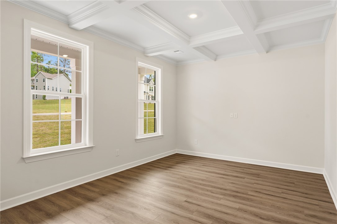 This bright room features elegant coffered ceilings and rich wood flooring.