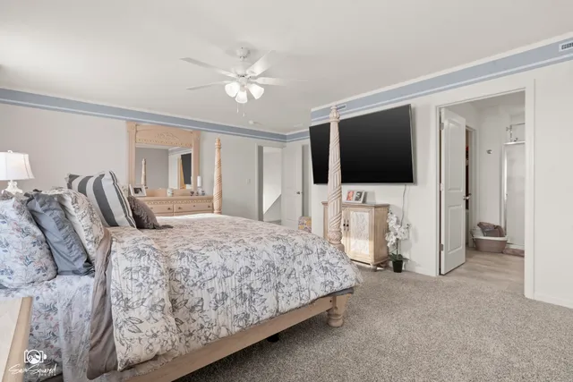 a bedroom with a bed and a flat tv screen on wall