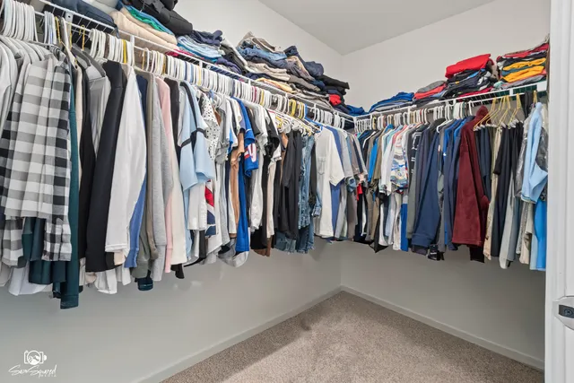 a view of walk in closet with clothes