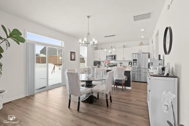 a dining room with stainless steel appliances kitchen island granite countertop a dining table chairs and view living room