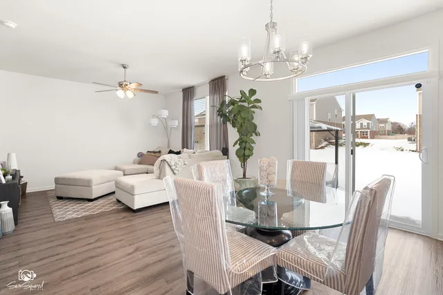 a view of a dining room with furniture a chandelier and wooden floor