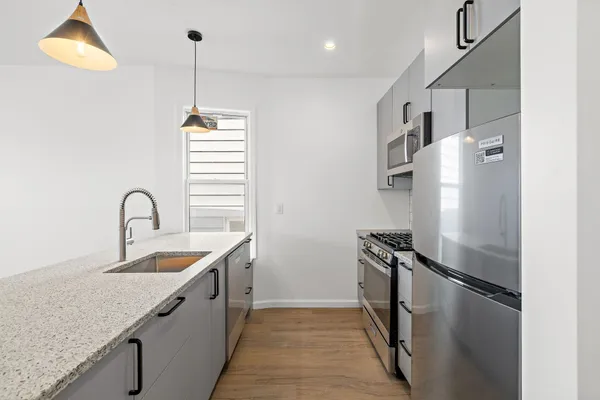 a kitchen with stainless steel appliances granite countertop a sink a stove and a refrigerator