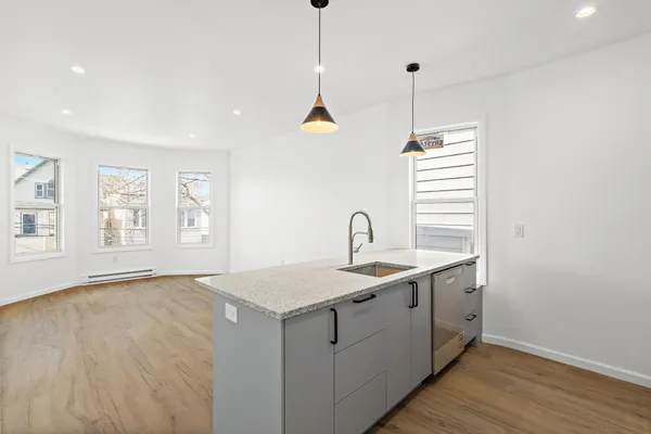 a kitchen with a sink a window and wooden floor